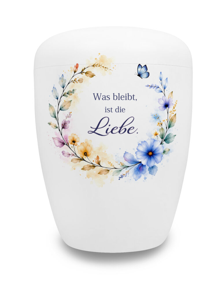 Weiße Urne mit Spruch "Was bleibt, ist die Liebe" in einem bunten Blütenring
